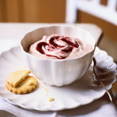 Damson fool in a white china pot with hazelnut shortbread biscuits on the side.